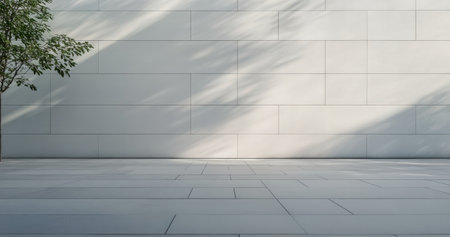 A single potted tree stands in a minimalist room, casting gentle shadows against a light colored wall. The serene environment showcases the beauty of simplicity.の素材