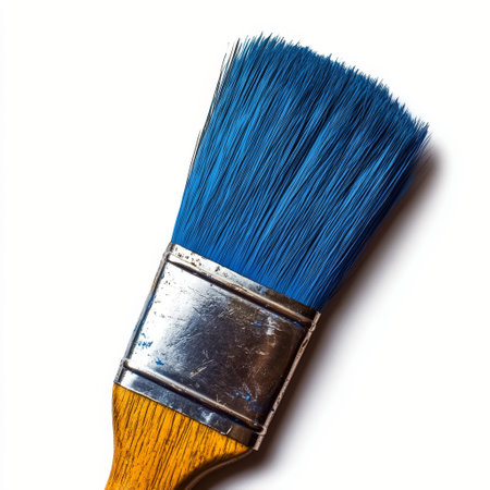 A close up view of a paintbrush featuring bright blue bristles and a wooden handle, ideal for painting, arts, and crafts. The brush is well maintained, showing its versatility.の素材