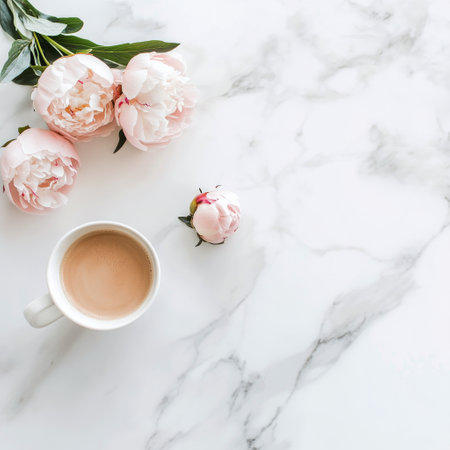 Fresh pink peonies are arranged next to a latte with heart latte art on a marbled surface, creating a stylish and inviting setting perfect for relaxation or enjoyment.の素材