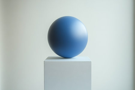 A glossy blue sphere is displayed on a sleek white pedestal in a contemporary interior. The minimalist design highlights the vibrant color and smooth surface of the sphere.の素材