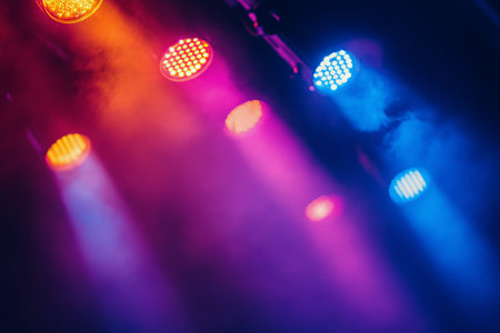 Bright and colorful lights shine down on an empty stage, creating an inviting atmosphere for upcoming performances and events.の素材