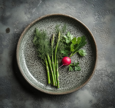 A variety of fresh vegetables and herbs are arranged on a textured plate.の素材