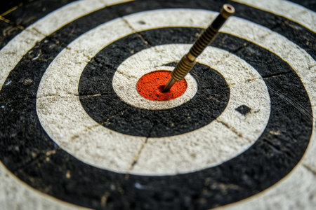 A red heart-tipped dart strikes the center of a black and white bullseye, symbolizing precision and focus in a serene environment.の素材