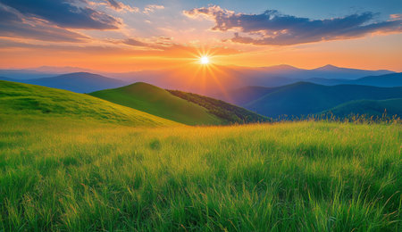 Bright sunlight casts a warm glow over lush green hills as the sun sets behind distant mountains, creating a serene atmosphere filled with natural beauty.の素材