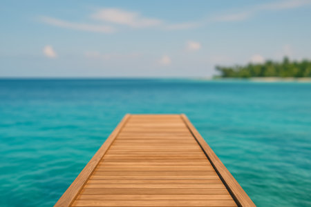 A wooden dock stretches out into clear turquoise waters under a bright blue sky. Lush greenery is visible in the distance, creating a serene atmosphere for relaxation.の素材