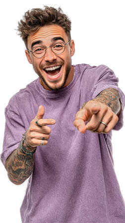 A young man with curly hair and glasses expresses joy by smiling and playfully pointing at the viewer. He wears a purple shirt and has visible tattoos on his arms.の素材