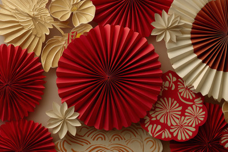 Bright red and gold paper fans are beautifully arranged together, creating a vibrant decoration for a festive occasion. The intricate designs add elegance to the setting..の素材