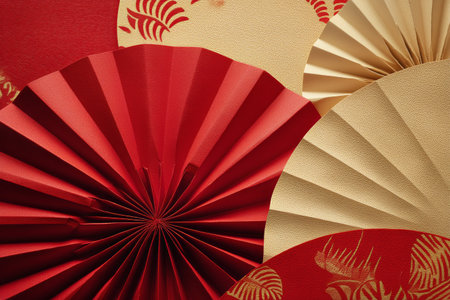 Bright red and gold paper fans are beautifully arranged together, creating a vibrant decoration for a festive occasion. The intricate designs add elegance to the setting.の素材
