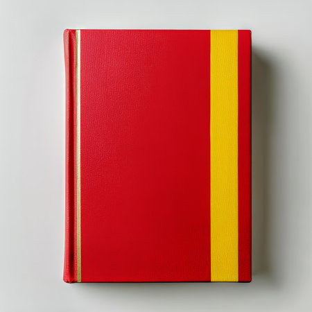 A striking red book rests on a neutral surface, featuring a yellow ribbon for bookmarking. The simple design highlights the bright colors, inviting readers to explore its content..の素材