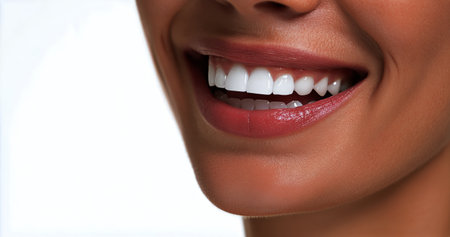 A woman displays a bright smile showing off her white teeth. The setting is minimalistic, focusing on her cheerful expression and healthy appearance.の素材