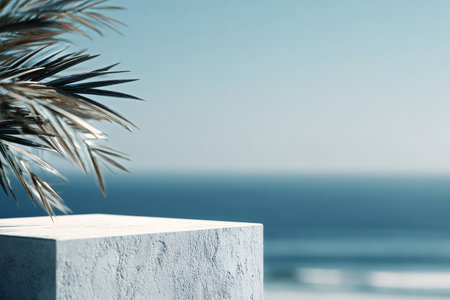 A clear blue sky and calm ocean stretch out in the background. Green palm leaves gently frame the scene, creating a tranquil setting. The sun shines brightly on a warm day.の素材