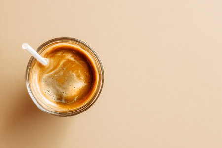 A glass filled with a creamy beverage showcases frothy texture on top. The scene captures warm natural light, emphasizing simplicity and elegance..の素材