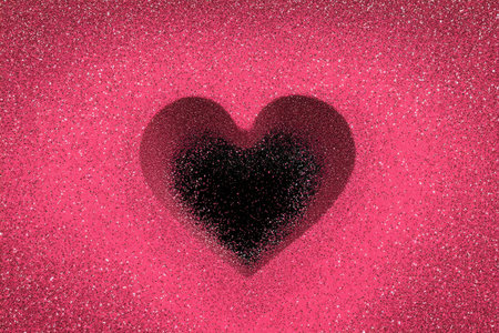 A black glitter heart sits on a bright pink glittery surface, creating a striking contrast. The sparkling backdrop enhances the overall festive and playful mood of the scene.の素材
