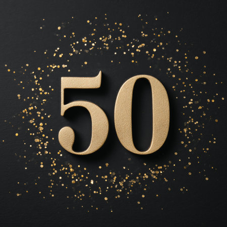 Gold glitter number fifty stands out against a black background with scattered golden sparkles, perfect for a celebration or milestone event. Details matter.の素材