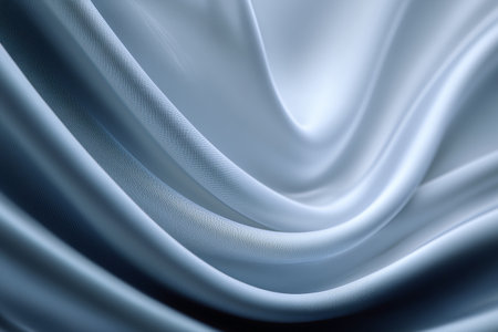 Silky fabric drapes gracefully in soft folds, revealing a blend of silver and dark blue hues under soft afternoon light. The smooth texture creates a luxurious and inviting feel.. Details matter.の素材