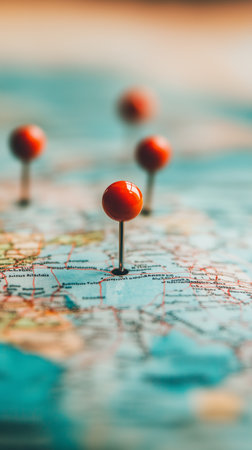 Bright red pins are placed on a world map, highlighting specific locations. This setup suggests planning and exploration for exciting journeys in the near future.の素材