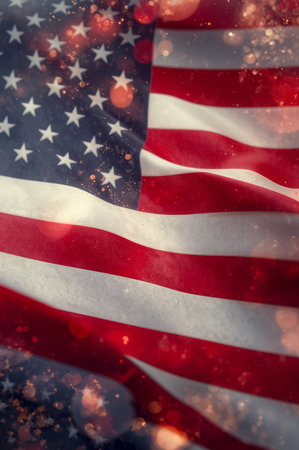 The American flag gracefully flutters in a light breeze, showing its vibrant colors. Soft lighting enhances the beauty and details of the stars and stripes against a dark background.の素材