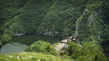 Young couple resting on a mountain watching beautiful river belowのeditorial素材