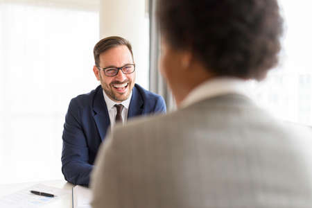 HR manager interviewing african american female job candidate applicant and looking at her during...