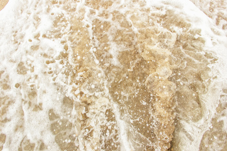 sea wave foam spread on the sandの写真素材