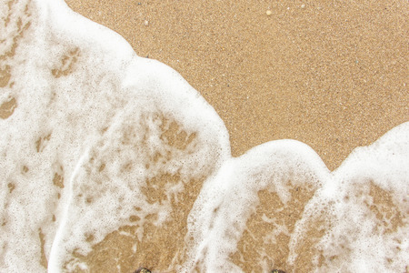 sea wave foam spread on the sandの写真素材