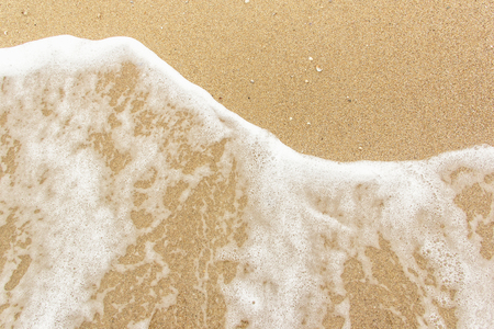 sea wave foam spread on the sandの写真素材