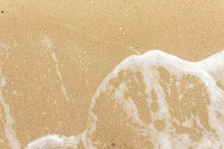 sea wave foam spread on the sandの写真素材