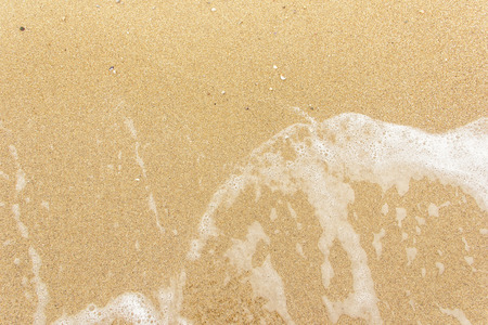 sea wave foam spread on the sandの写真素材