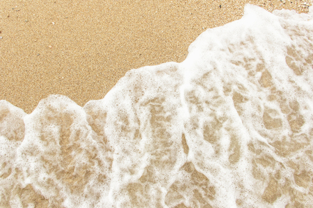 sea wave foam spread on the sandの写真素材