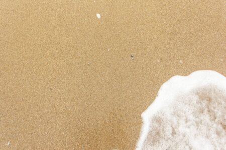 sea wave foam spread on the sandの写真素材