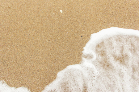 sea wave foam spread on the sandの写真素材