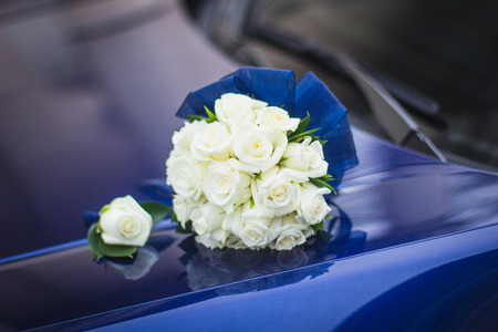 Wedding bouquet of white roses in bright colors with a blue handle.の写真素材