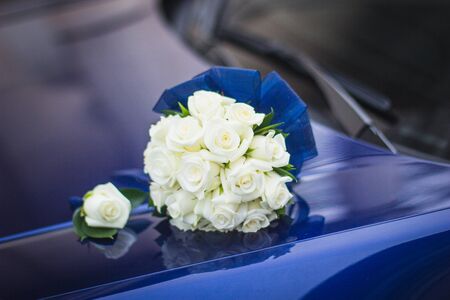 Wedding bouquet of white roses in bright colors with a blue handle.の写真素材