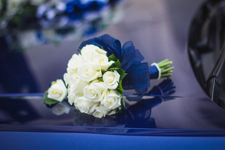 Wedding bouquet of white roses in bright colors with a blue handle.の写真素材