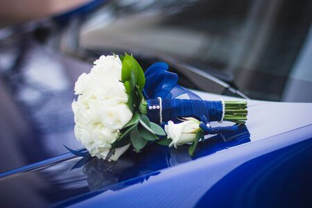 Wedding bouquet of white roses in bright colors with a blue handle.の写真素材