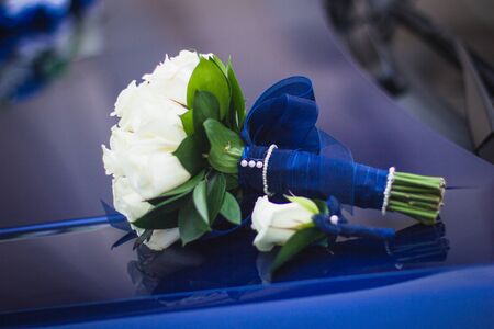 Wedding bouquet of white roses in bright colors with a blue handle.の写真素材