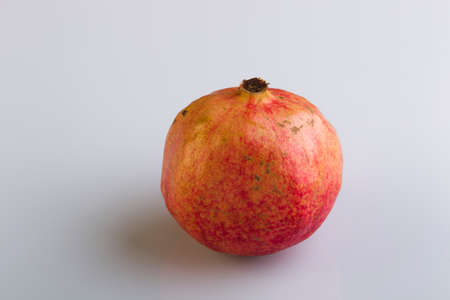 Pomegranate on a white plastic background, studio lightingの写真素材
