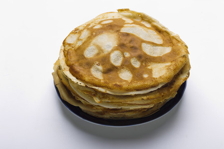 Pancakes on a plate with blue kamkoy on a white background, studio lighting, the view from the topの写真素材