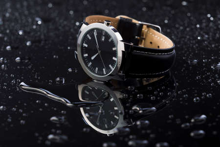 Watches with water drops on black acrylic background, studio lightingの写真素材