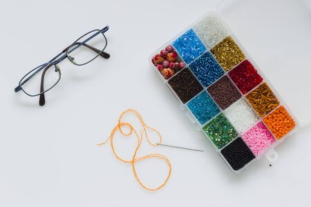 Set for embroidery with beads on a white background, natural light, top viewの写真素材