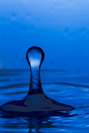 Bursts, spray, falling water droplets on a blue background, studio lighting, Macroの写真素材