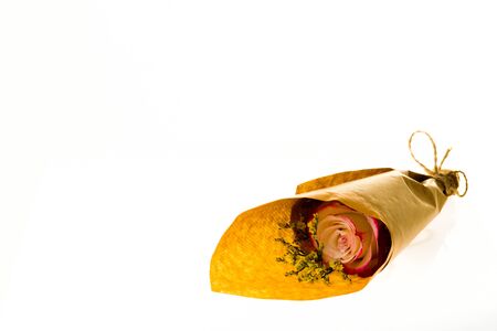 Bouquet of flowers Limonium Sweetness and roses in parchment paper on a white plastic acrylic background, studio lightingの写真素材