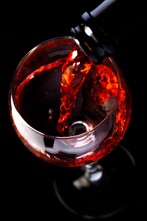 Red wine in wine glasses and wine bottle on a black background, silhouette, minimalism, studio lightingの写真素材