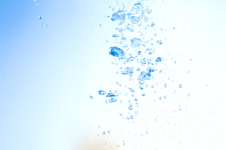 Flowing water, drops, sprays, splashes on a neutral background