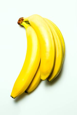Yellow ripe bananas on white acrylic background, studio lightの写真素材