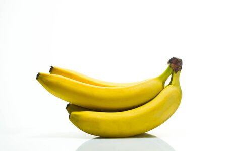 Yellow ripe bananas on white acrylic background, studio lightの写真素材