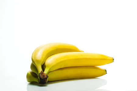 Yellow ripe bananas on white acrylic background, studio lightの写真素材