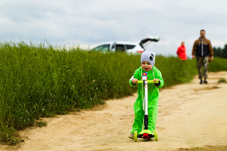 Little girl is riding a scooterの写真素材