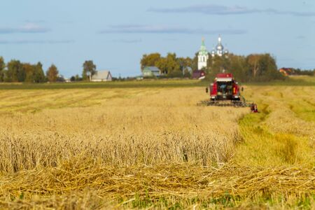 Wheat field, agricultural machinery for harvestingの写真素材