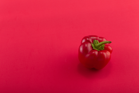 Sweet bellpepper. Red sweet bellpepper on a red background. One. Studio light. Top viewの写真素材